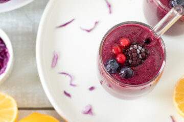 Red cabbage berry smoothie on a kitchen table. Top view. Healthy vegan blended drink.