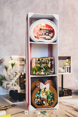 Three tiny miniature roomboxes in a vertical rack