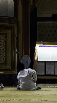 Muslim praying alone near mosque window
