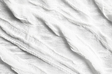 Soft, textured white fabric folded in elegant waves, ideal for backgrounds or design elements