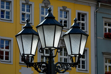 Historyczne latarnie miejskie, latarnia uliczna w starym stylu, Historic lanterns against the background of the city buildings in the sunlight, lantern in the city, Old style lantern street light