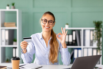 A professional accountant banker lady sits at her desk in a modern office. She smiles at the...
