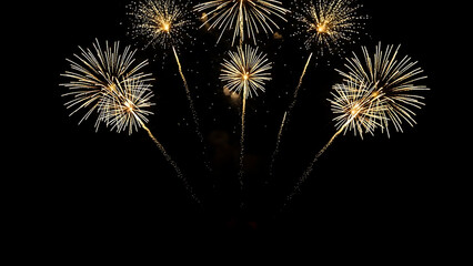 Fototapeta premium golden fireworks exploding dark night sky brilliant light displays for festive celebrations new year holiday background.