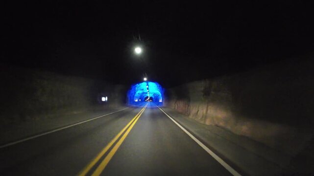 Motorhome driving pov through a blue illuminated cave in the famous Laerdal Tunnel in Norway
