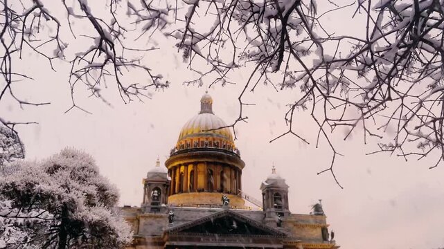 St. Petersburg, Russia - November 23, 2025: View of the snow-covered St. Isaac's Square with snow-covered trees and St. Isaac's Cathedral on a winter day at sunset. 4K