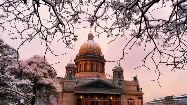 St. Petersburg, Russia - November 23, 2025: View of the snow-covered St. Isaac's Square with snow-covered trees and St. Isaac's Cathedral on a winter day at sunset. 4K