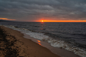 Baltic Sea sunset with waves washing sandy beach in December Latvia