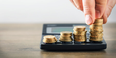 Tax savings concept with coins on calculator