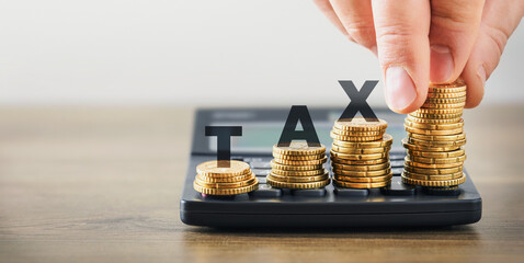 Tax savings concept with coins on calculator