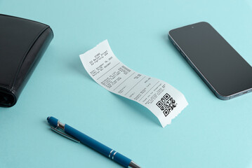 Modern expense tracking concept with smartphone, wallet, pen and paper receipt on blue background, representing digital finance, bookkeeping, payments, and personal or business expense management