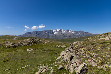 Mountain view of the Emparis Plateau in the Arves Massif, Hautes-Alpes, French Alps, featuring rugged peaks and alpine meadows.