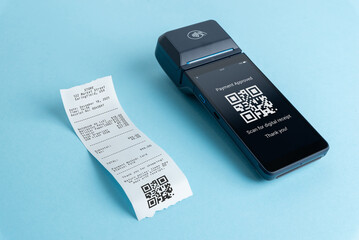 POS terminal displaying payment approved message with qr code receipt on blue background, contactless payment and digital receipt concept for modern retail systems