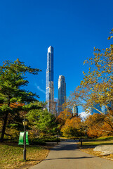 Obraz premium Central Park autumn path with Manhattan skyscrapers and blue sky above NYC