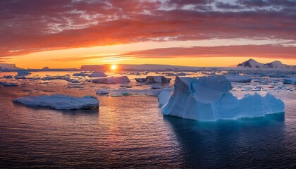 A Serene Sunset Casts Vibrant Colors Over Icebergs In The Arctic Sea Creating A Stunning Natural Landscape