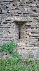 Fen&ecirc;tre verticale ancienne dans un mur en pierre