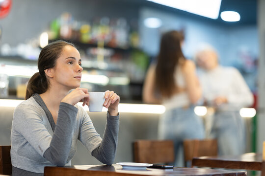 Pretty girl drinks coffee in a cafe interior
