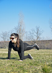 Woman with visual disabilities exercising in the park and stretching