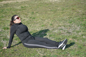 Woman with visual disabilities exercising in the park and stretching