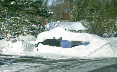 snow buried car on the driveway in winter blizzard
