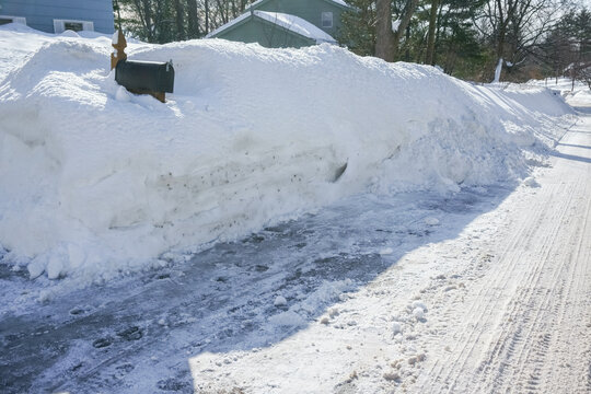 mailbox buried by snow pile by the street side in winter after snow storm