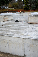 Large earthworks project site for large stormwater retention system, concrete lid poured, construction worker in background, residential development in progress
