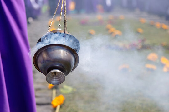 Burning incense carried during a traditional religious procession in Antigua, Guatemala. Rising smoke creates a spiritual atmosphere symbolizing faith, devotion, culture, and sacred rituals.