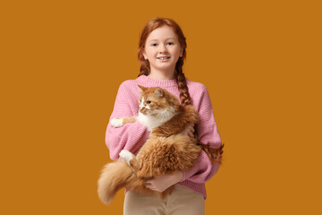 Obraz premium Redhead teenage girl with cute cat on orange background