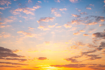 Sunset or sunrise sky with a vibrant gradient of orange, gold, and soft blue. Clear atmosphere with wispy clouds. Peaceful, natural light background. hope, freedom, new day and inspirational Concepts
