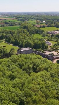 ch&acirc;teau seneffe amidst green cover surrounding trees distant town picturesque backdrop enhancing charm historic site to left right pans aerial of de 
