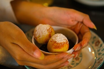 Poffertjes , Fluffy dutch pancakes or traditional Dutch batter cakes in paperbowl. Food for breakfast, sweet snack.