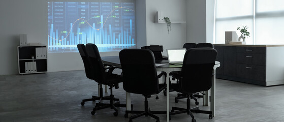 Interior of data scientist's office with workplace, laptops and diagrams projection on wall