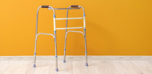 Medical walker near orange wall