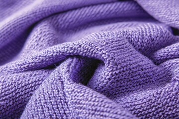 Soft purple fabric rests in folds on a flat surface, showing knit texture and detail in lighting