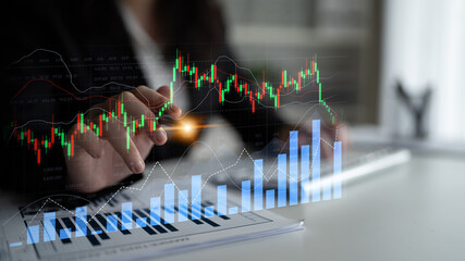 A professional analyzes financial graphs with stock market data in a modern workspace. The image captures the essence of strategic investment and market insights. Scalp