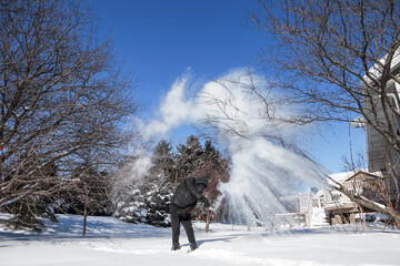 Teenager throwing a bottle of boiling water that freezes into ice crystals on contact with sub zero arctic air