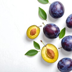 Overhead shot displays ripe purple fruit alongside green leaves, against a white backdrop. One fruit is cut in half