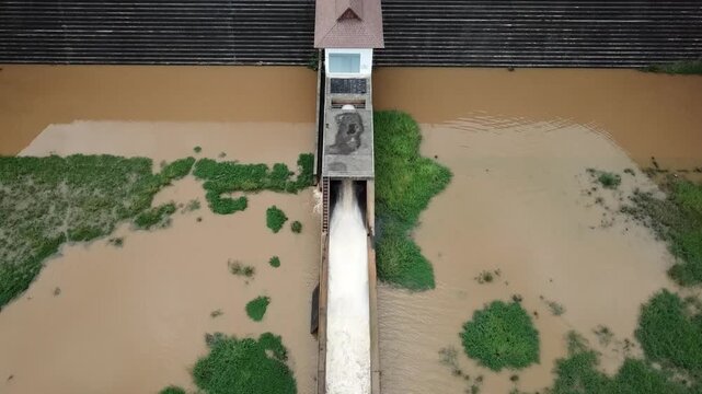 Aerial view of drainage channel while releasing water. Drainage channel is a natural or constructed watercourse or channel, having a definite bed and sides or banks, through which water flows.