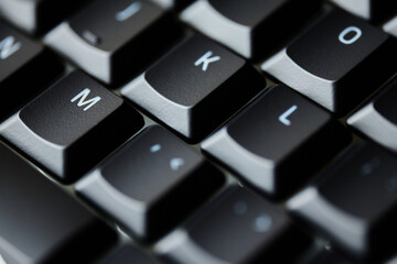 Top view macro of black mechanical keyboard keys with white letters and soft lighting