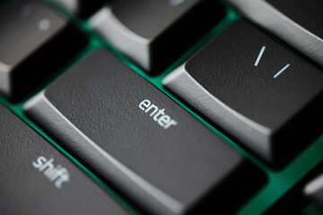 Close up of Enter key on mechanical gaming keyboard with green RGB backlight