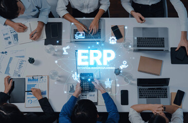 A diverse team collaborates in a modern office environment, engaging with laptops and digital tools, focusing on the ERP system and enhancing business processes. Trope