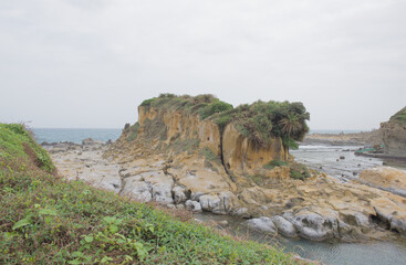 A cinematic panoramic view of the "Guardian Rock," a natural sandstone formation resembling a lion or sphinx, located at the Heping Island Geopark in Heping Island, Keelung, Taiwan.