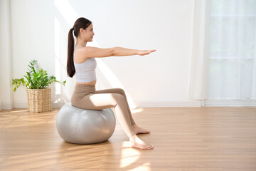 Woman sitting and doing fitness ball workout