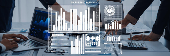 Business professionals collaborate on marketing planning, analyzing data visualizations and charts on laptops, showcasing teamwork and strategic insights in an office environment. Axiom