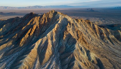 Aerial View of Majestic Mountain Range with Rugged Peaks and Arid Landscape at Sunset.