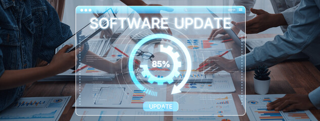 A group of professionals engaged in a software update process, showcasing progress on a digital interface alongside various business charts in a modern office setting. Trope