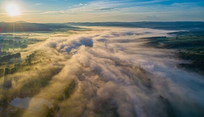 Breathtaking Aerial View of a Misty Valley at Sunrise with Golden Light.