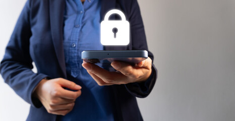 A businesswoman holds a cell phone with a glowing padlock symbol, representing digital security and data protection in corporate mobile device use.