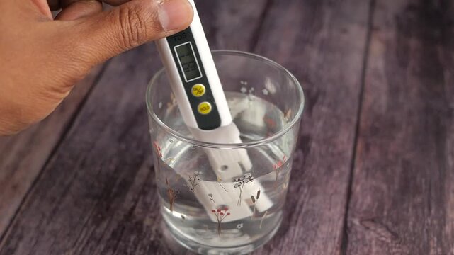 Measuring water quality with a digital meter in a glass