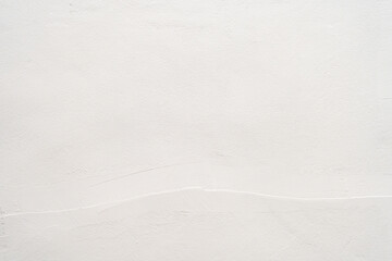 White plaster wall texture background with subtle cement brush strokes for copy space.