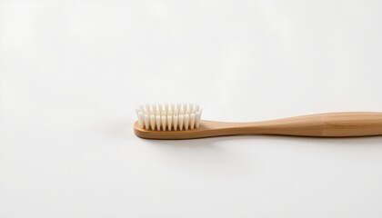 A wooden toothbrush holder placed in front of two toothbrushes, one with bristles visible. The holder has a handle like shape and is situated next to the brushes on a flat surface.